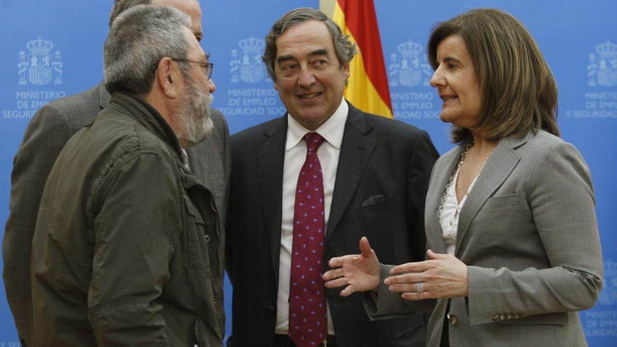 Báñez conversa con el líder de UGT, Cándido Méndez (izquierda) y el presidente de la patronal CEOE, Juan Rosell, el pasado abril.