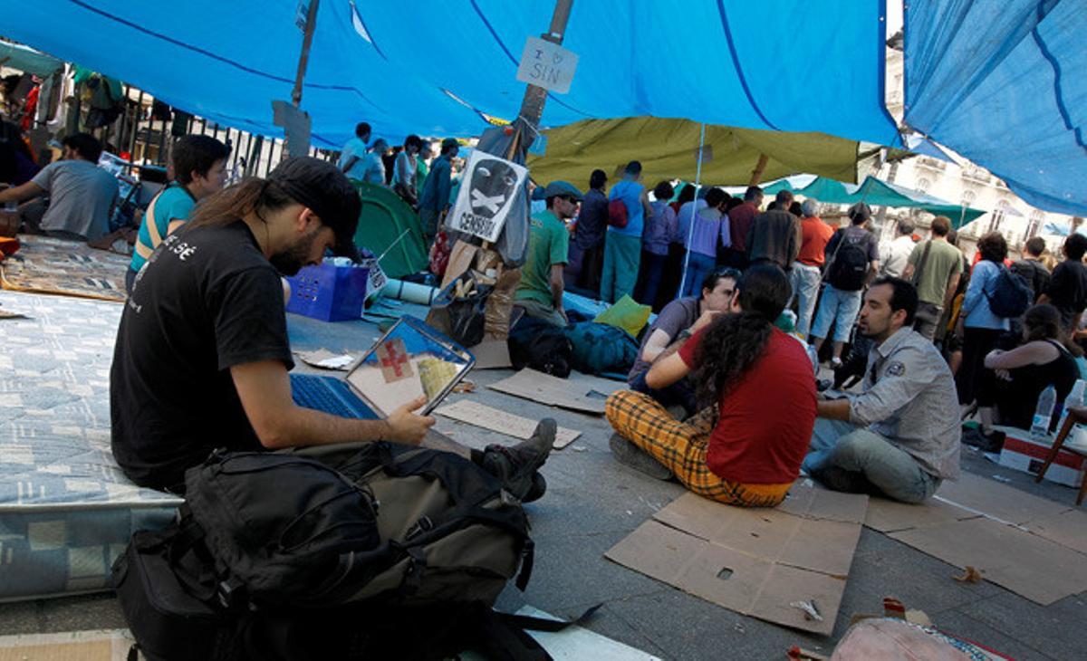 Un jove es connecta a internet en l’acampada de la Puerta del Sol.
