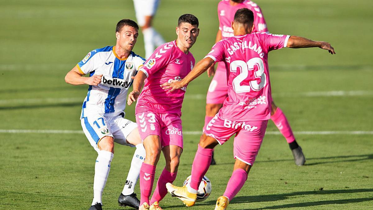 Sergio Ruiz (3) es acosado por un jugador rival mientras Dani Castellano despeja el balón, en el choque ante el Leganés.