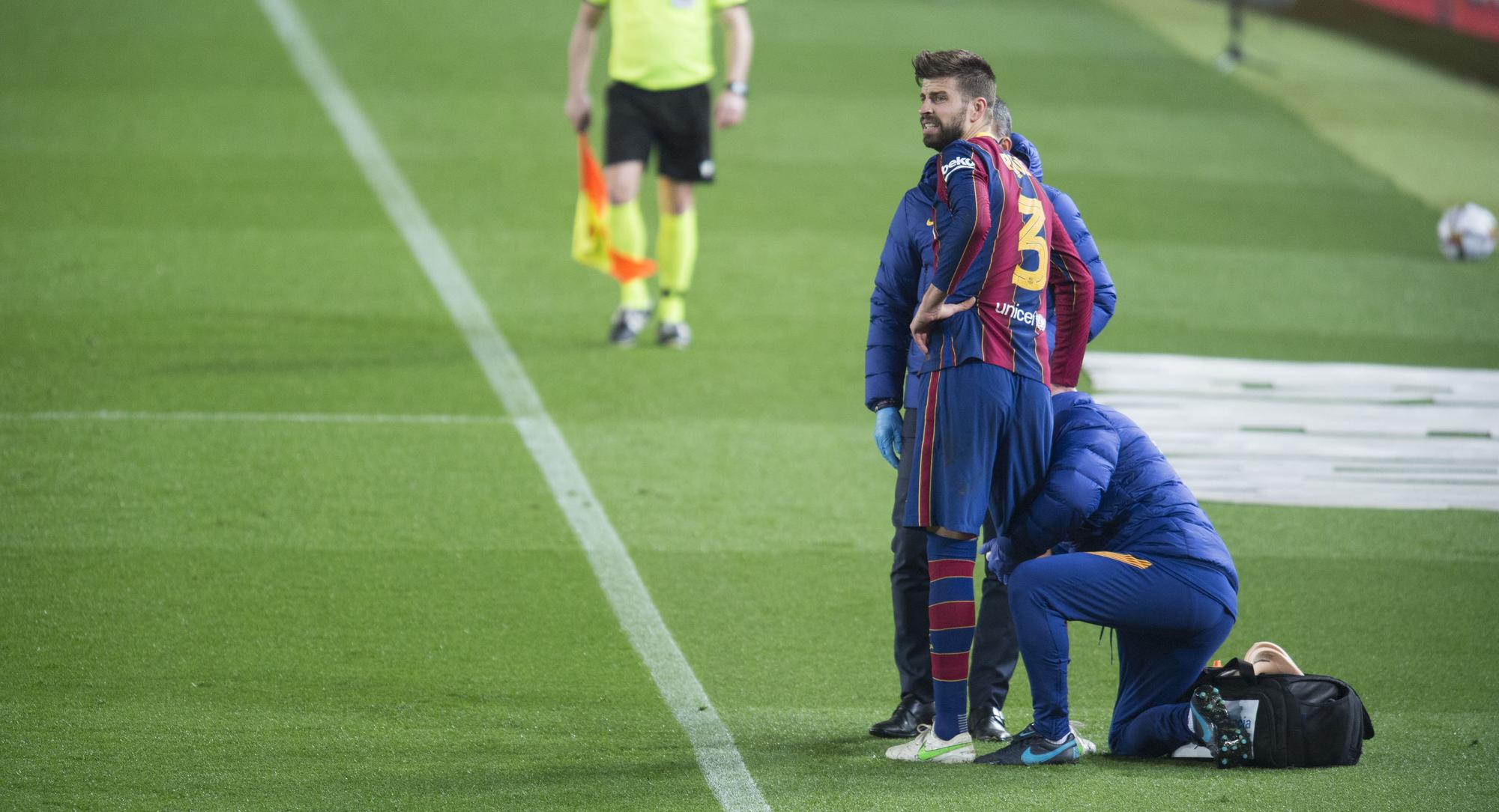 Piqué es atendido por los doctores antes de volver a salir al partido contra el Sevilla.