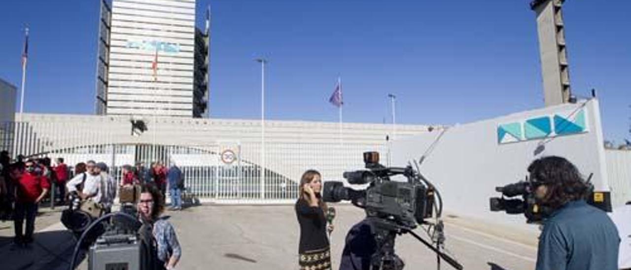 Un grupo de cámaras ante la sede de RTVV en Burjassot con su último logotipo, reducido a la expresión «Nou», en tonos verdes y azules.