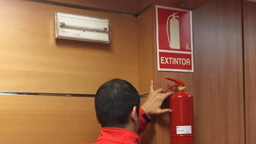 Un operario de Incotex revisando un extintor.