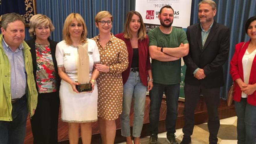 Pepi Irles sujeta el trofeo, arropada por la alcaldesa, el rector de la UMH y la directora general de Cooperación, Ferris y otros organizadores.