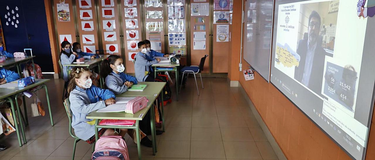 Una clase del colegio Virgen Reina, de Gijón, durante el la proyección del vídeo en el que el presidente de Escuelas Católicas, Simón Cortina, explica la importancia de la red concertada a los alumnos. | Marcos León