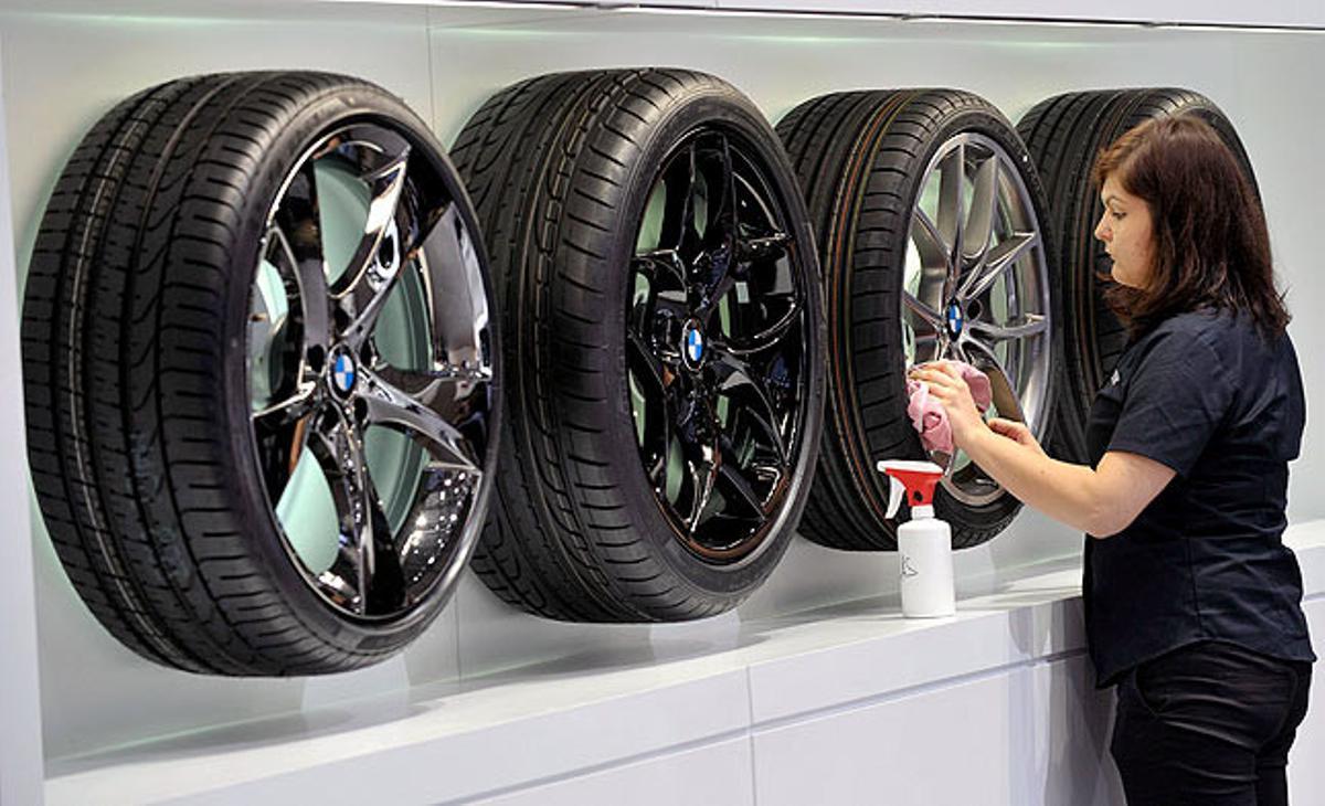 Una treballadora del Saló Internacional del Motor de Ginebra neteja unes rodes. Una treballadora del Saló Internacional del Motor de Ginebra neteja unes rodes.