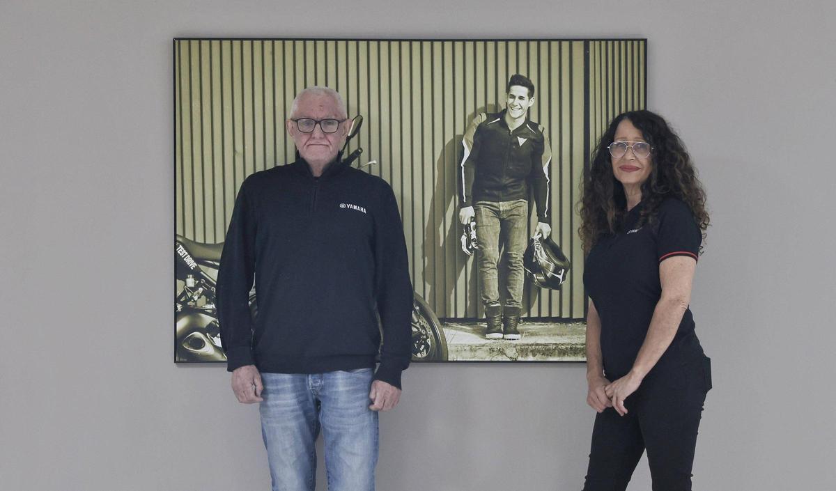 Lluís Salom y María Horrach posan con una imagen de su hijo Luis en las oficinas de su nuevo concesionario.