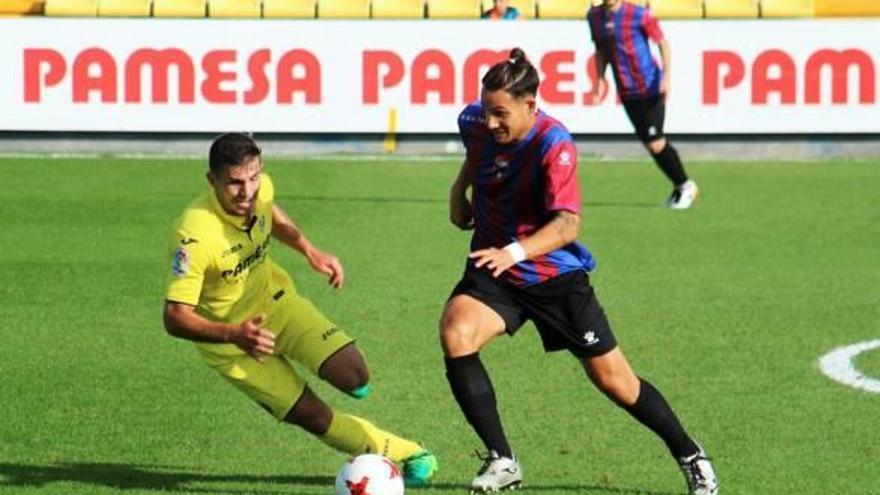 El azulgrana Luis Acosta controla el balón ante un rival del Villarreal C.