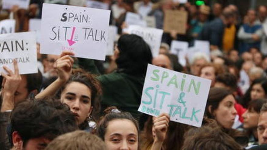 Cartells de &#039;Sit and talk&#039; entre els manifestants asseguts davant la Delegació del govern espanyol, convocats per Tsunami Democràtic