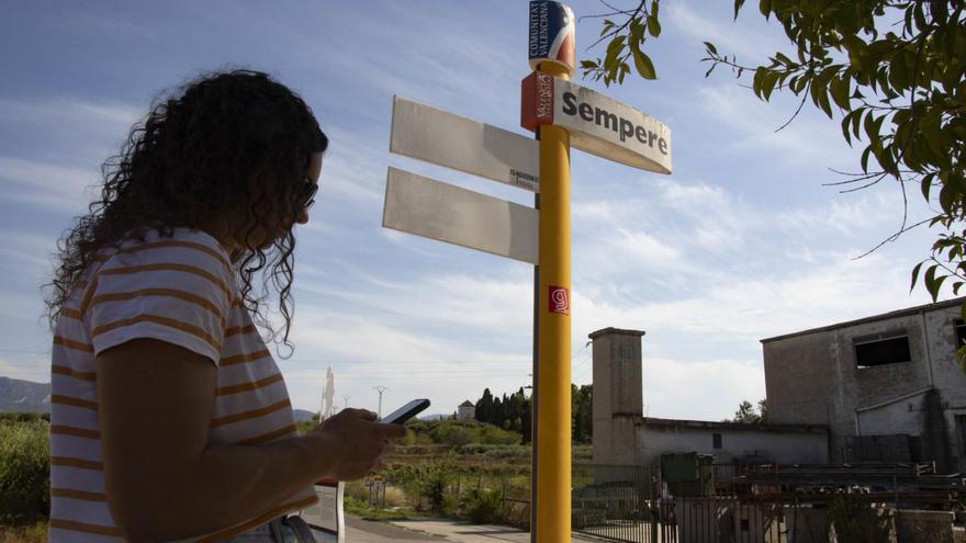Una joven consulta su teléfono móvil en una de las entradas de Sempere, ayer. | PERALES IBORRA
