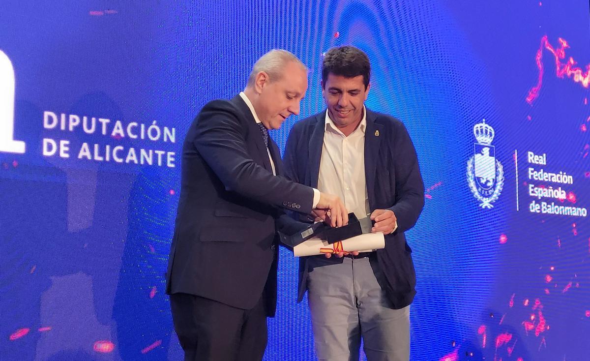 El presidente de la Federación Española de Balonmano, Paco Blázquez, entrega la insignia y medalla de oro a Carlos Mazón