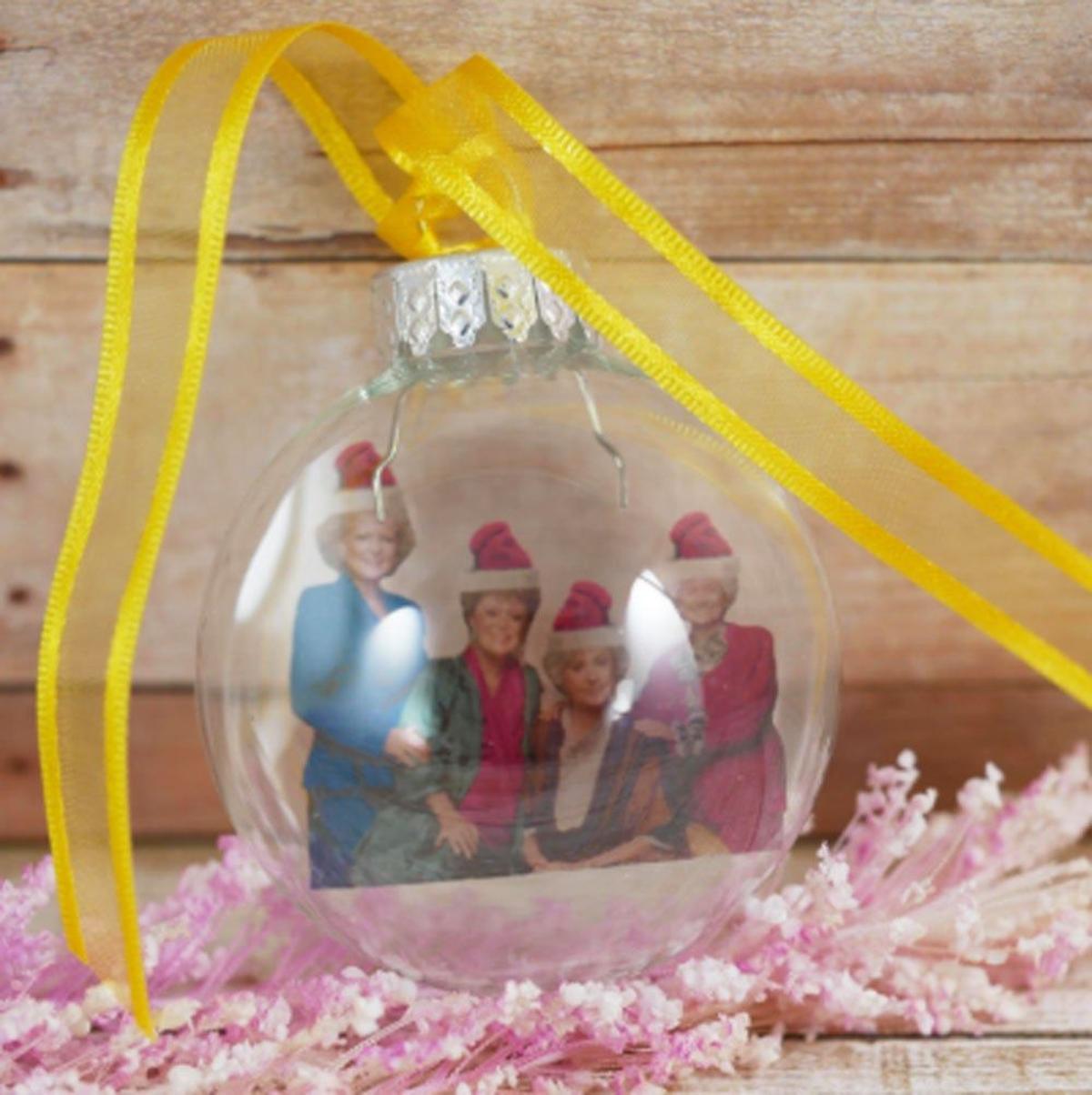 Bola transparente con foto real de las 4 chicas de oro con su gorrito de navidad. (Precio: 7,51 euros)