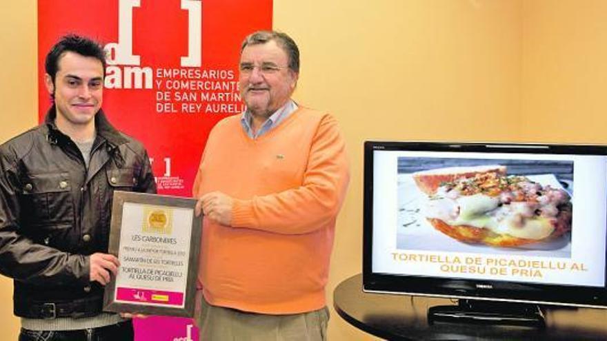 Ricardo González, a la derecha, entrega a Pablo Fernández el diploma de ganador del Certamen de tortillas de San Martín.