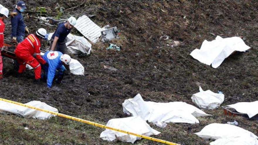 Cadáveres tapados y parte del fuselaje en pleno rescate.