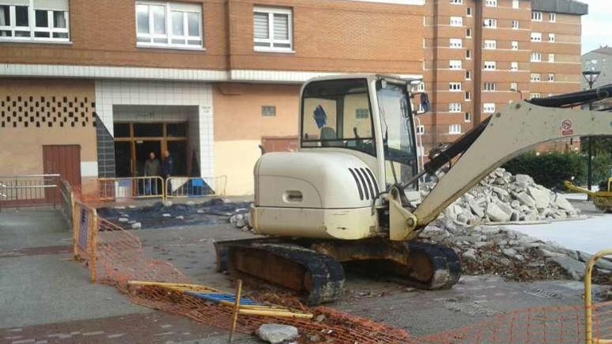 Una de las máquinas reposa frente a una pila de escombros en la parcela central del barrio de El Polígono.