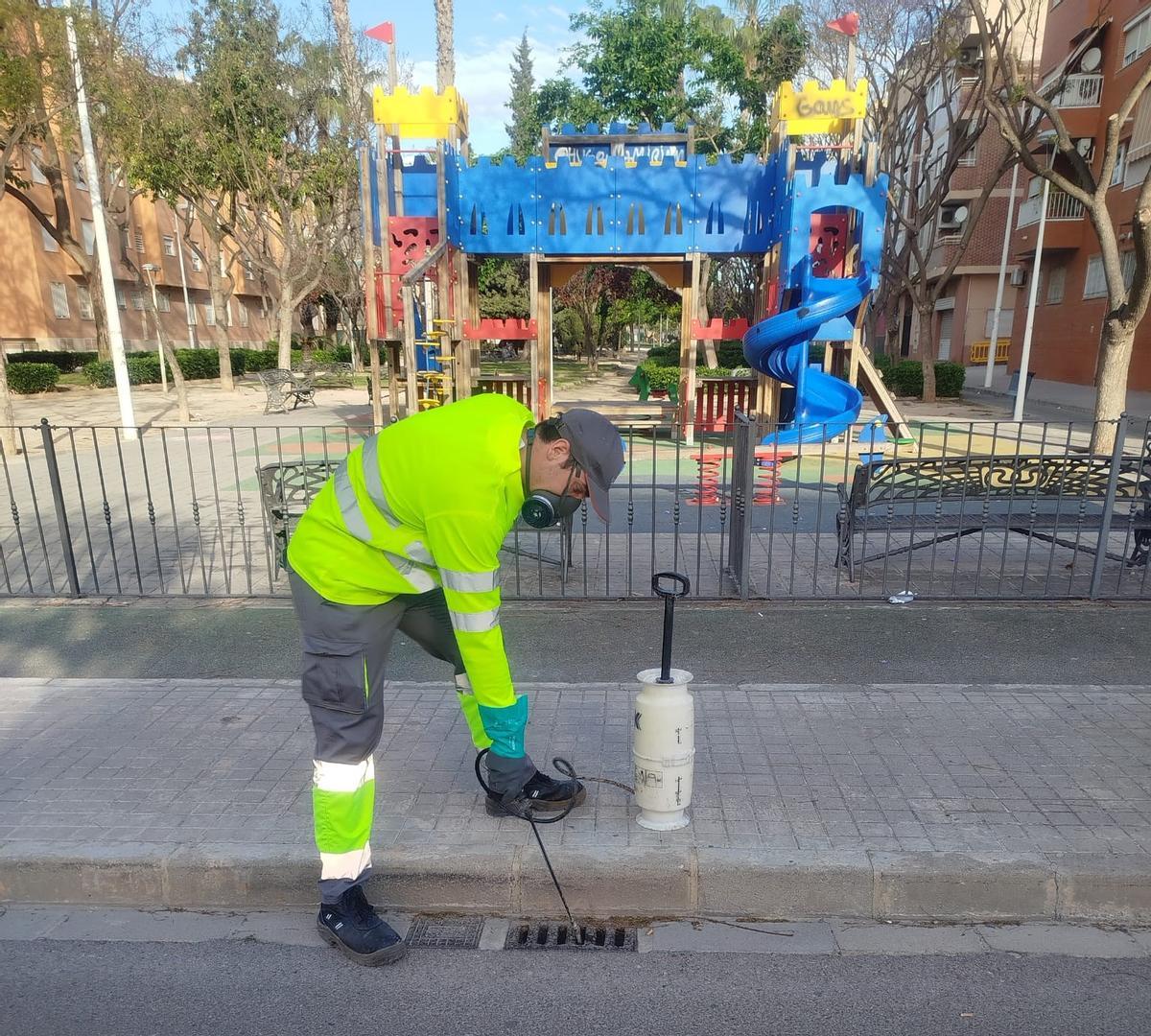 Trabajos de fumigación en un imbornal de un parque de Manises.