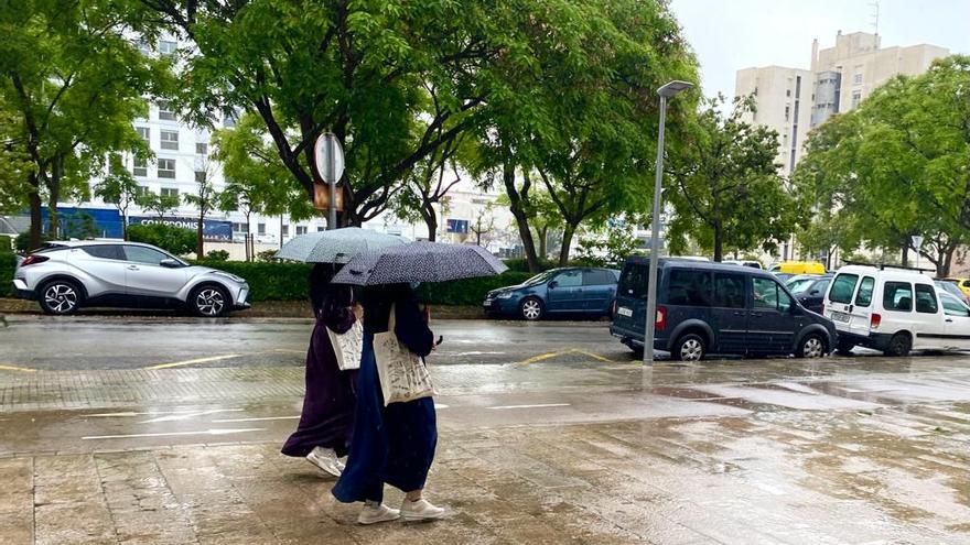 Dos mujeres musulmanas se protegen de la lluvia bajo su paraguas