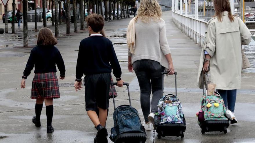 Madres y niños van a la escuela.