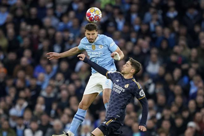 Manchester Citys Ruben Dias jumps for the ball with Real Madrids goalkeeper Andriy Lunin during the Champions League quarterfinal second leg soccer match between Manchester City and Real Madrid at the Etihad Stadium in Manchester, England, Wednesday, April 17, 2024. (AP Photo/Dave Thompson)