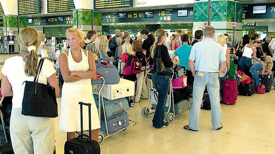 Turistas extranjeros en la cola de facturación en el aeropuerto de Gran Canaria.    ANDRÉS CRUZ