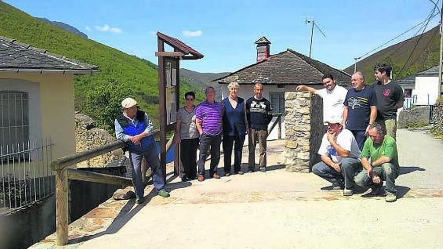 Los vecinos de Tablao, a los lados del muro que divide la plaza pública del pueblo.