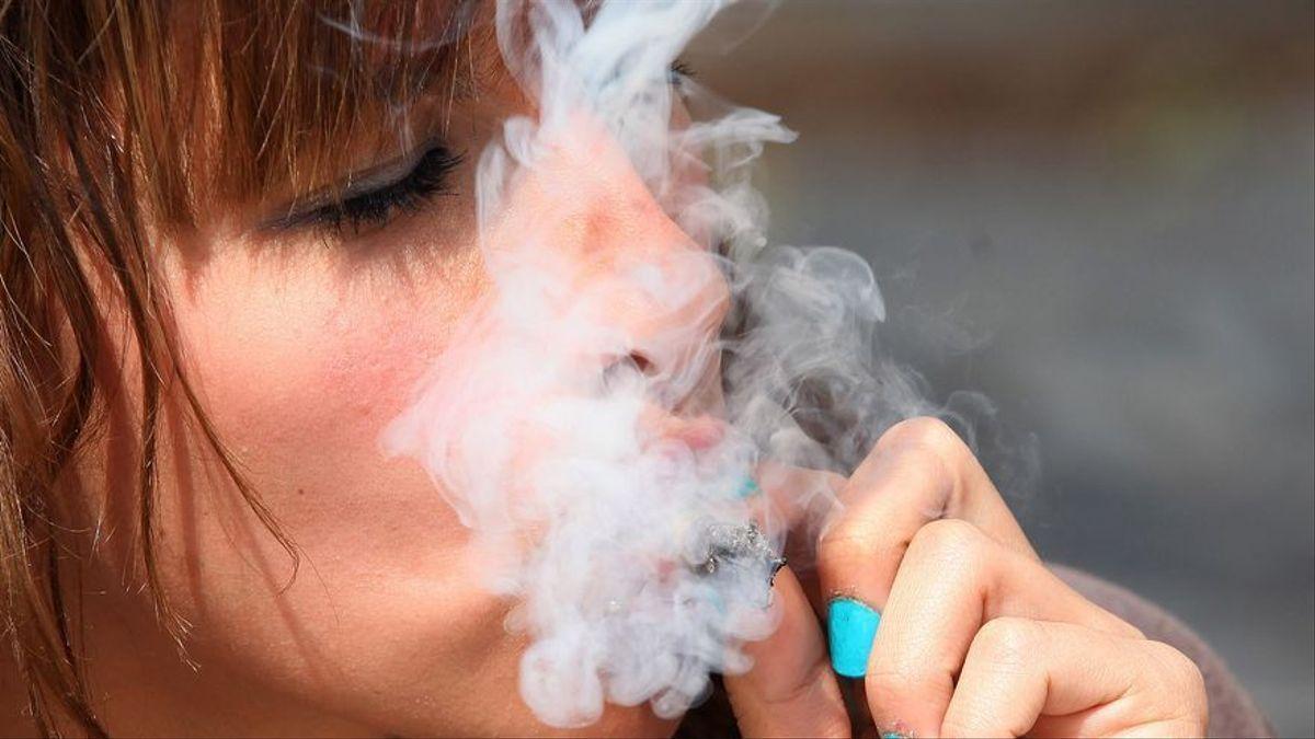 Una mujer fuma un cigarrillo