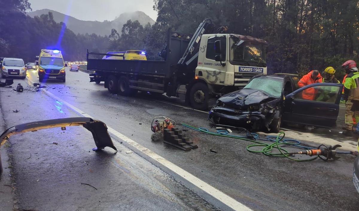 Vehículo accidentado cerca de Ledoño, una grúa y efectivos de emergencias y sanitarios, en el punto del accidente.