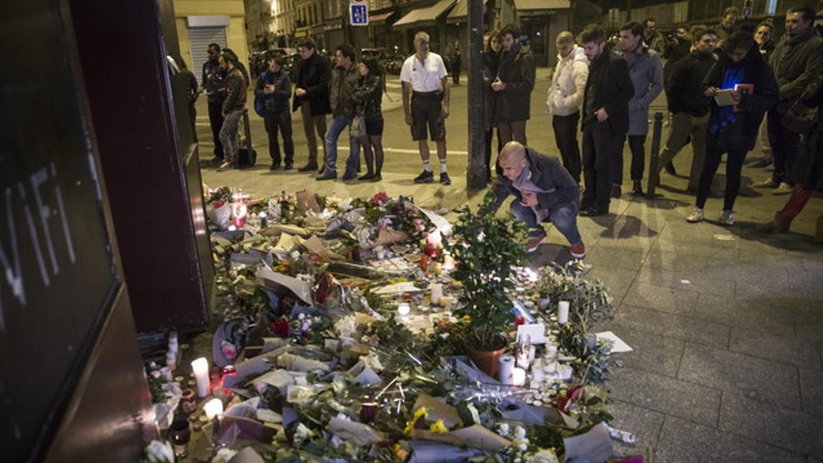 Los parisinos dejan flores y velas en honor a las víctimas de los atentados, en el café Carillon, en París.