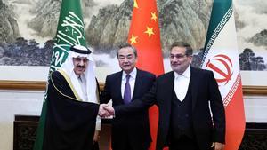 El asesor de seguridad saudí Musaad bin Mohammed Al Aiban estrecha la mano al secretario del Consejo de Seguridad Nacional iraní, Ali Shamkhani, en presencia del director de la oficina de la Comisión de Asuntos Exteriores Wang Yi, el pasado 10 de marzo en Pekín.