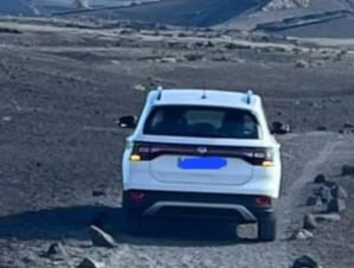 Turistas circulando con su coche por el sendero peatonal en el Volcán del Cuervo.