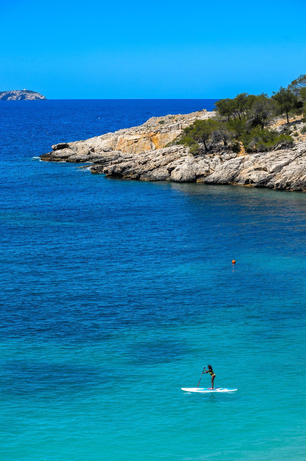 A girl paddle surfing in Ibiza.