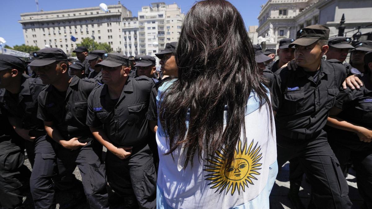 Una ciudadana argentina se manifiesta contra las reformas impulsdas por Javier Milei frente a un grupo de policías.