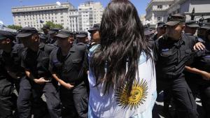 Una ciudadana argentina se manifiesta contra las reformas impulsdas por Javier Milei frente a un grupo de policías