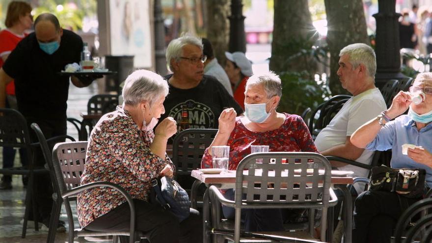 Varias personas en una terraza en Gandía.