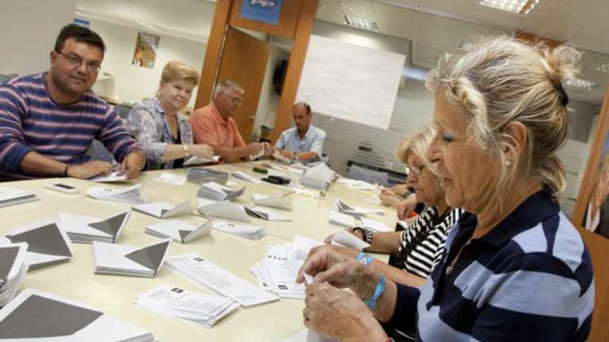 Militantes del PP ensobran votos en la sede local.