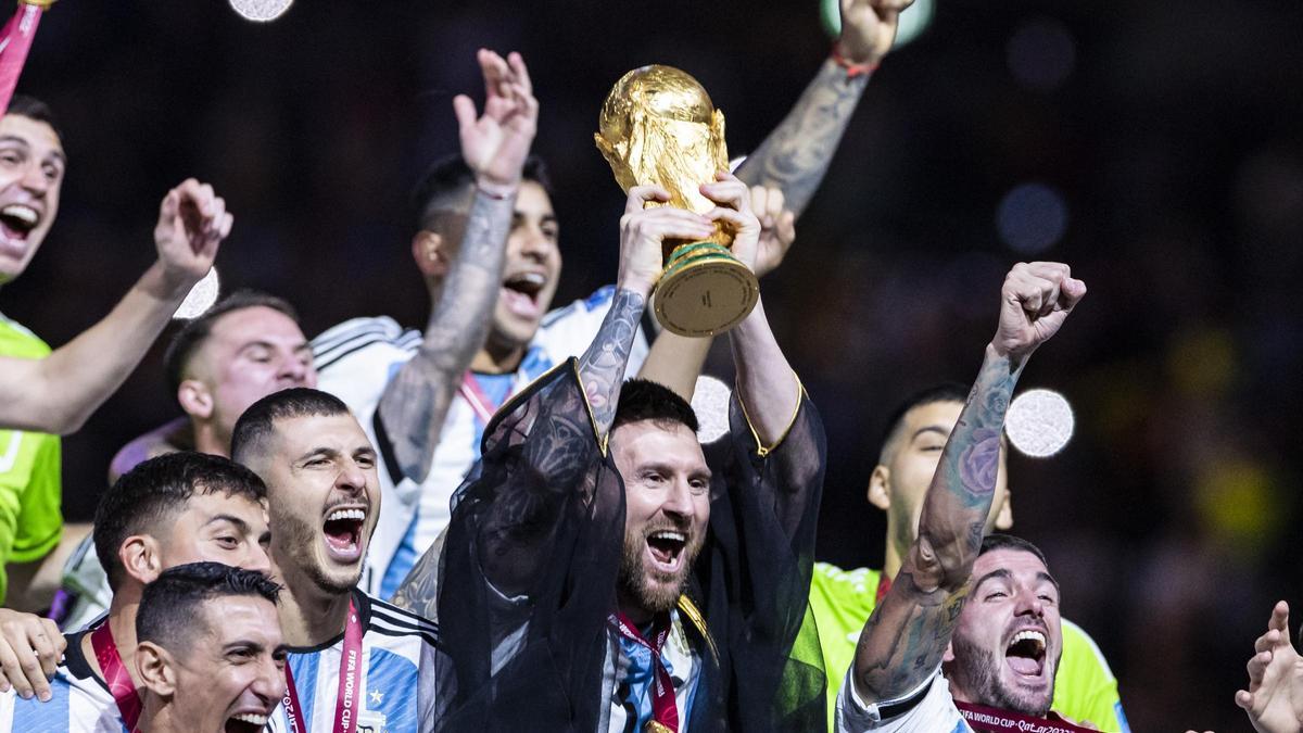 Argentiniens Lionel Messi jubelt mit WM - Pokal und seiner Mannschaft über den gewinn der Weltmeisterschaft.