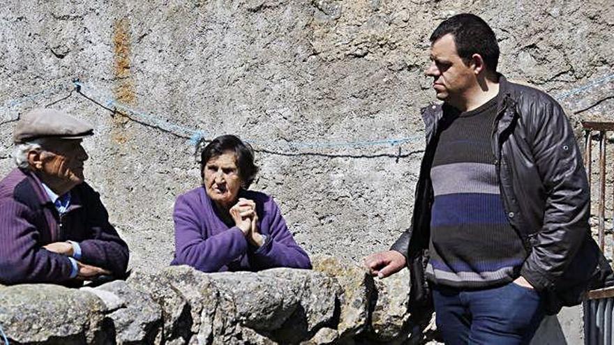 Dos habitantes de Fresno de Sayago charlan con el candidato de Unidas Podemos a la puerta de su casa.