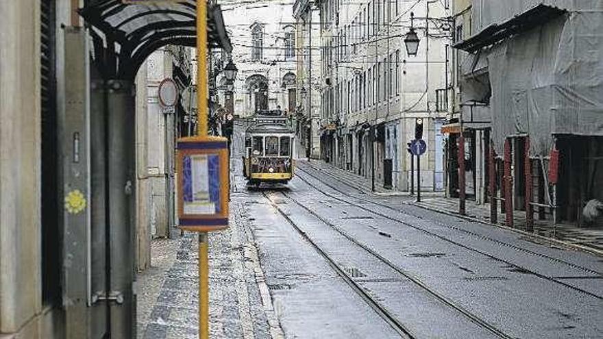 Un tranvía circula por una calle desierta de Lisboa.