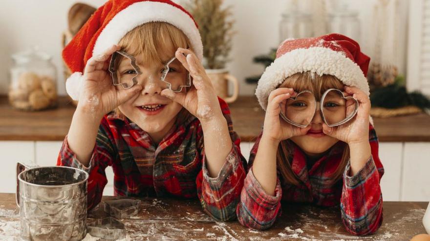 Dos niños con gorros y pijamas navideños.| |  FREEPIK