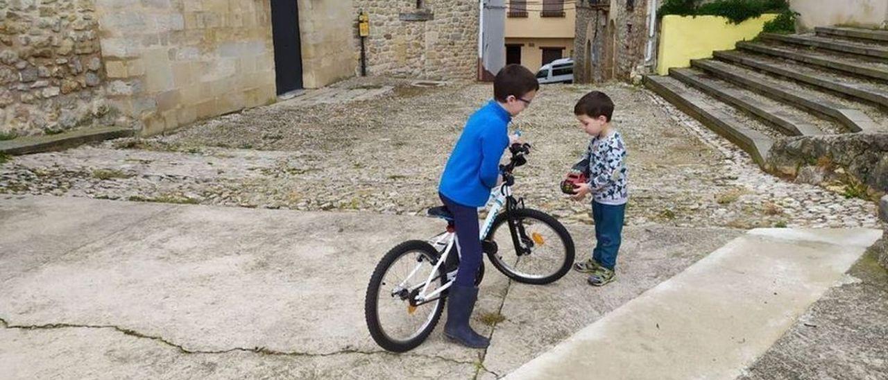 Dos niños juegan en una calle de Herbers, en Els Ports.