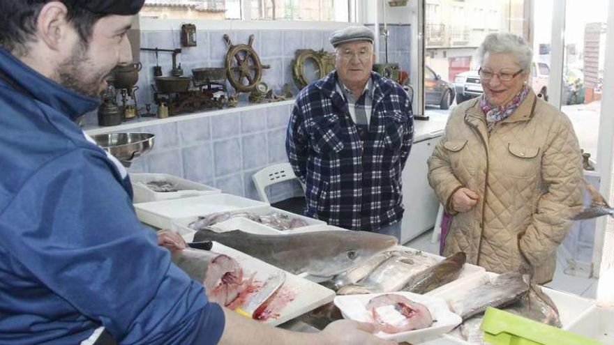 Abel Simes sirve en su pescadería de Cantodarea toros del tiburón capturado en la ría de Marín. // S.A.