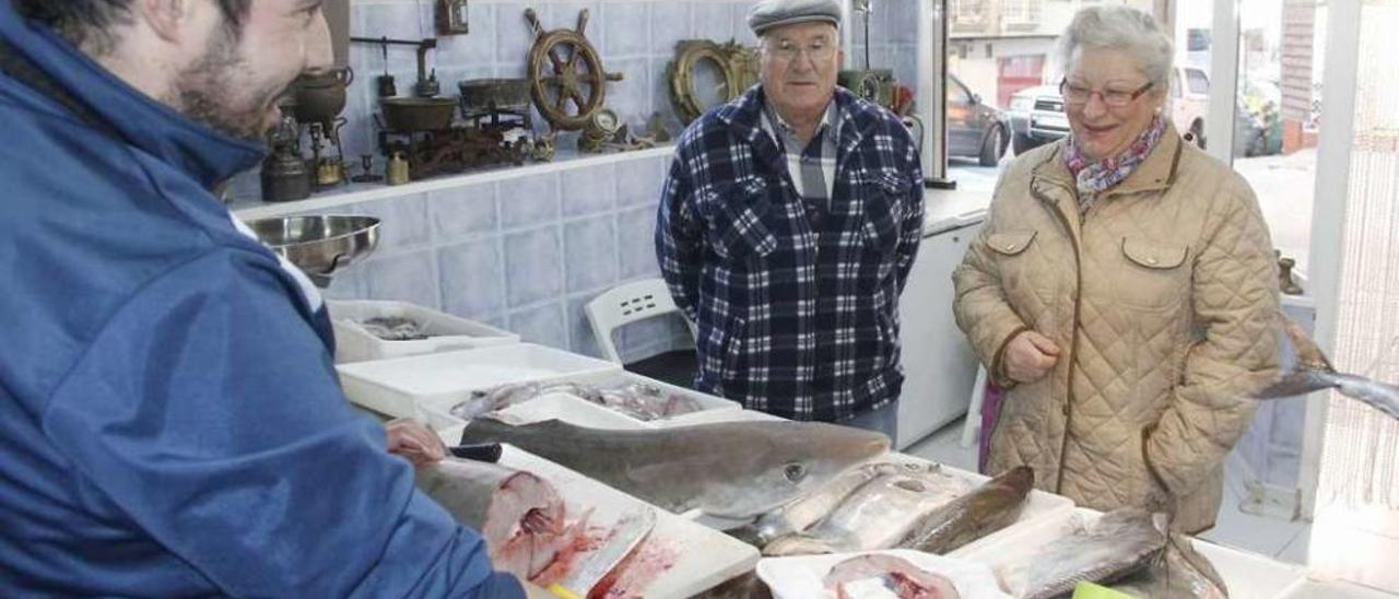 Abel Simes sirve en su pescadería de Cantodarea toros del tiburón capturado en la ría de Marín. // S.A.