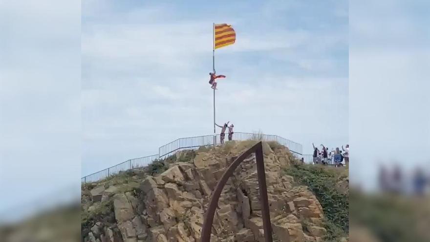 Un grup arrenca la senyera que oneja a una platja de Blanes