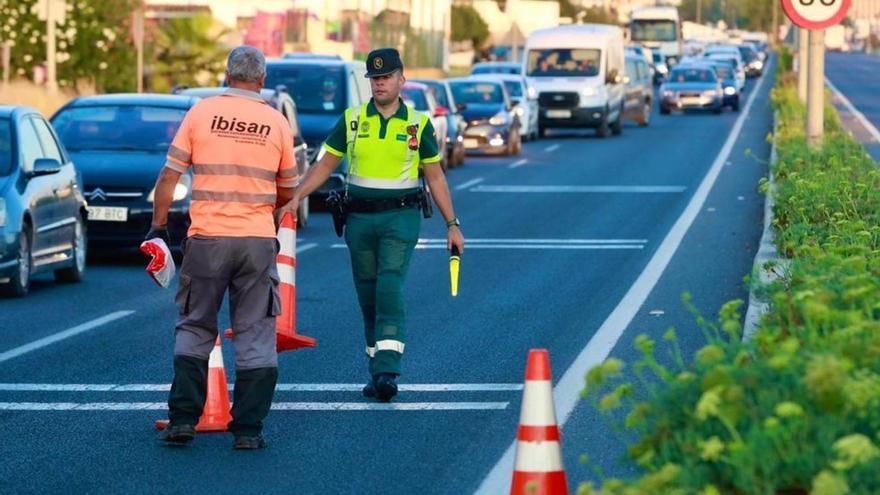 Un agente de la Guardia Civil retira los conos después del accidente mortal en Can Guillemó, en la mañana de ayer.