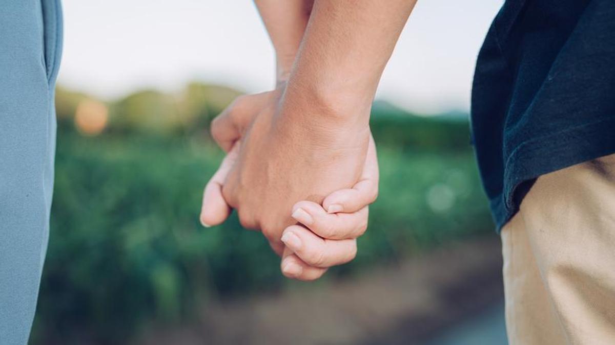 Dos personas cogidas de la mano.