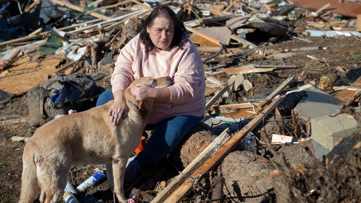 Una mujer y su perro, ante los restos de la casa de un familiar.