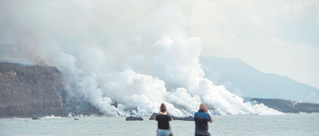 Vecinos de La Palma fotografían la llegada de la lava al mar.