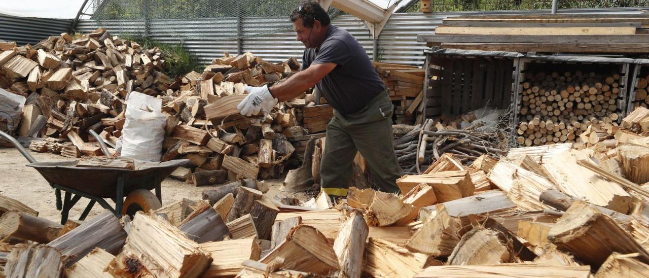 Un miembro de la Comunidad de Montes de Coruxo trata la leña acopiada antes de su distribución a los clientes