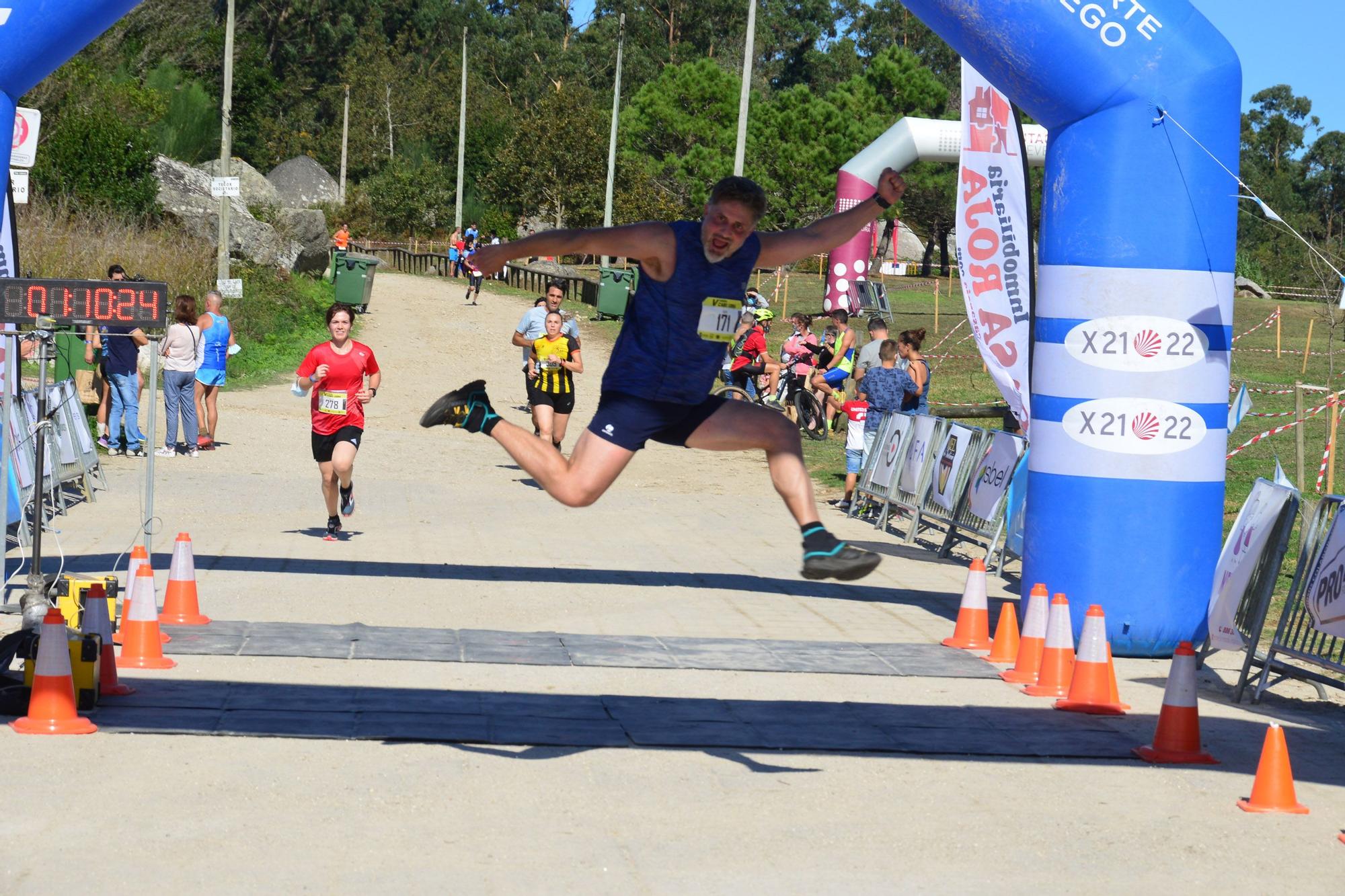 Un corredor celebra su entrada en meta tras completar los 10 kilómetros del Cross Cabo Udra.