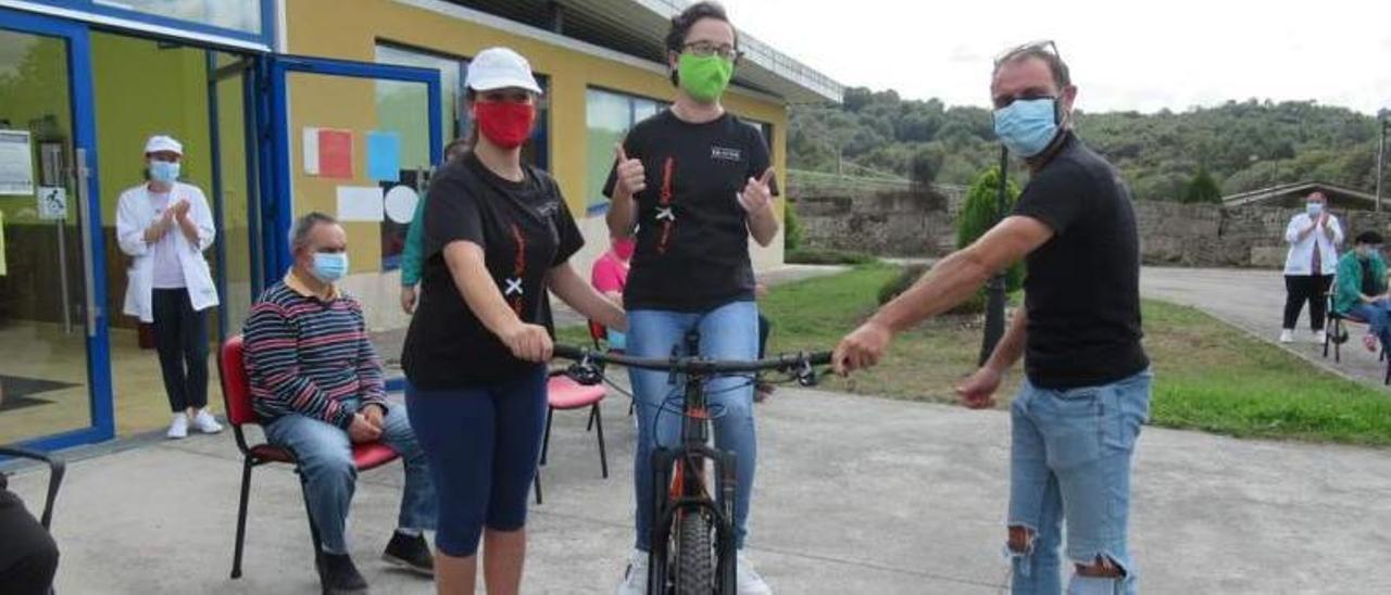 Fernando Pena (dcha.) junto a usuarios de Aspadeza y la bicicleta con la que correrá la Titan Desert.