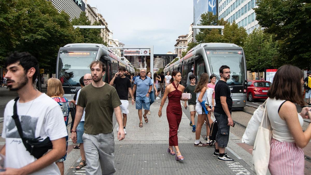 Decenas de personas pasean por la parada del tranvía de plaza Aragón, en Zaragoza.